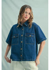 Woman wearing a blue denim jacket against a light gray background
