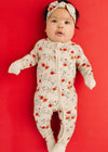 Baby wearing a floral onesie on a red background