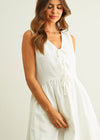 Woman wearing a white sleeveless dress on a plain background