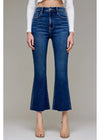 Person wearing blue flared jeans on a plain background