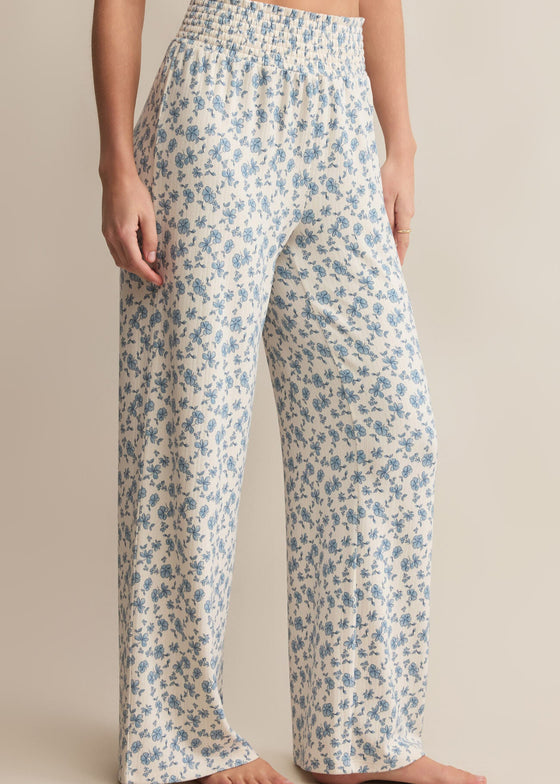 Floral patterned pants worn by a person on a beige background