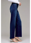 Person wearing blue wide-leg jeans on a gray background