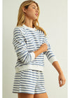 Woman wearing a blue and white striped outfit on a plain background