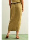 Person wearing a long olive green skirt on a plain background