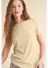 Woman wearing a light yellow t-shirt against a beige background