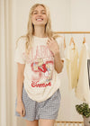 Woman wearing a graphic t-shirt with 'Kalahari 98' design in a clothing store.