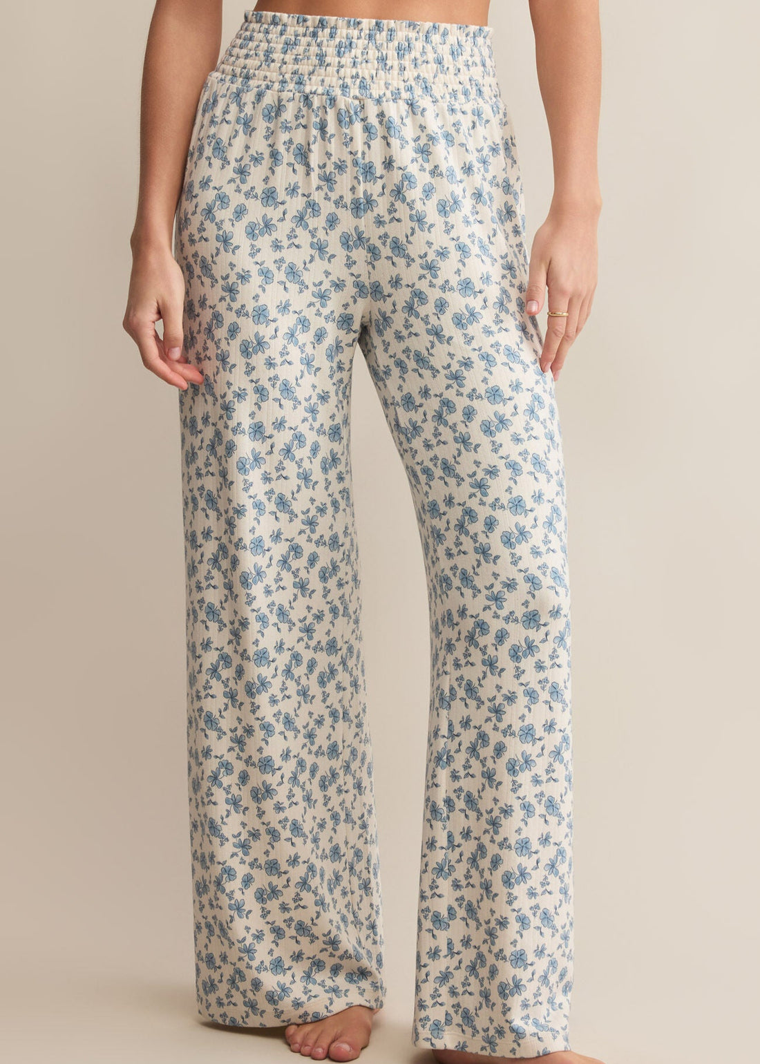  Floral patterned pants worn by a person on a beige background