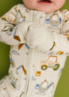 Baby in a onesie with vehicle pattern on a green background