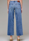 Blue jeans worn by a person on a gray background