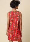 Woman wearing a red floral dress against a beige background