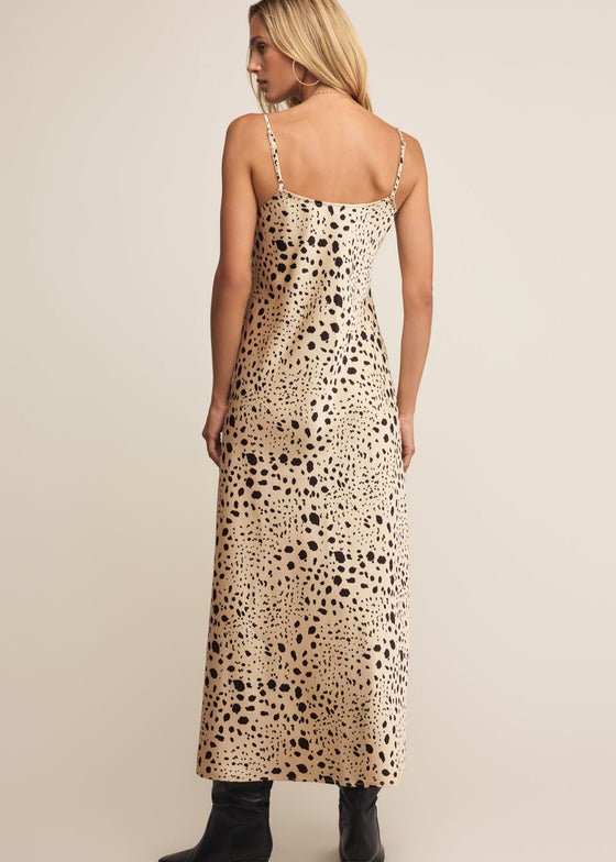 Woman wearing a leopard print dress on a beige background