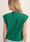 Green sleeveless top worn by a person on a plain background