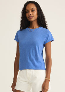  Woman wearing a blue t-shirt and white shorts on a beige background