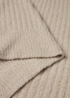 Close-up of beige textured fabric with a folded edge