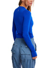 Person wearing a blue long-sleeve top and blue cargo pants on a white background