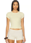 Woman wearing a light-colored crop top and shorts on a white background