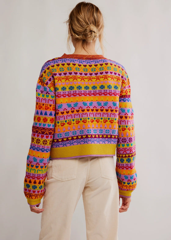 Person wearing a colorful patterned sweater on a plain background
