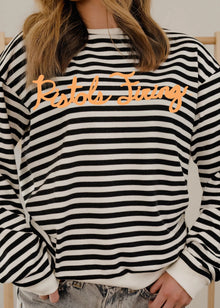  Black and white striped sweatshirt with 'Rothy Thing' text worn by a person.