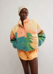  Person wearing a colorful jacket with a gradient design on a plain background