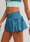 Blue athletic skirt worn by a person on a plain background