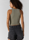 Woman wearing a green tank top and black shorts on a white background
