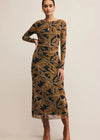 Woman wearing a patterned dress with long sleeves on a beige background