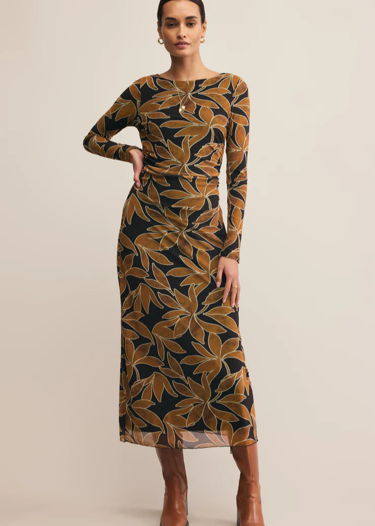  Woman wearing a patterned dress with long sleeves on a beige background