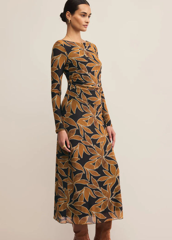 Woman wearing a long-sleeve dress with a leaf pattern on a beige background