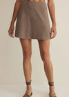 Person wearing a brown skirt on a plain background
