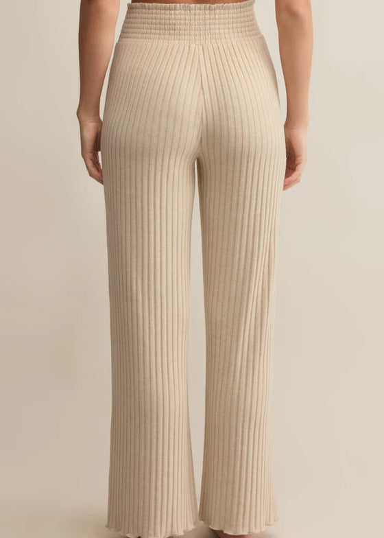 Beige ribbed pants worn by a person on a beige background