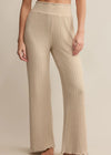 Beige ribbed pants worn by a person on a beige background