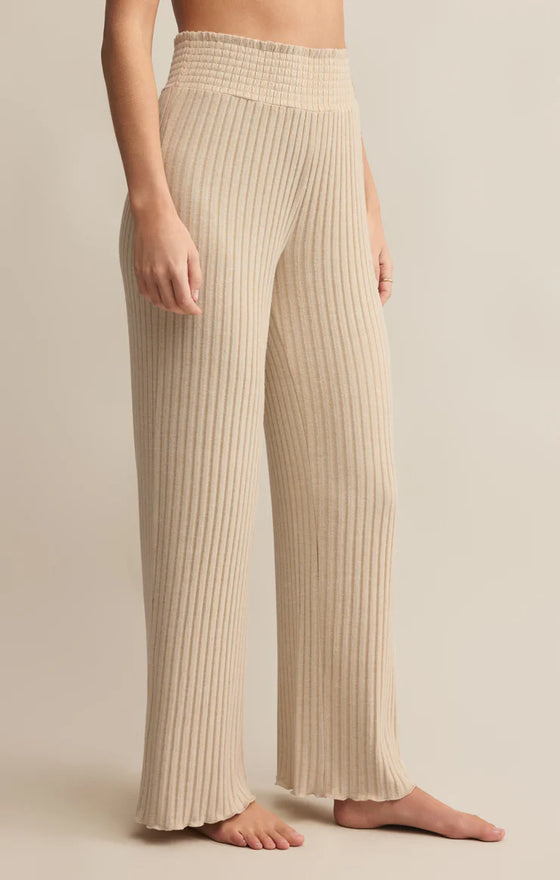 Beige ribbed pants worn by a person on a beige background