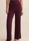 Maroon ribbed pants worn by a person on a beige background