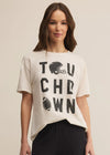 Woman wearing a beige t-shirt with 'TOUCHDOWN' print on a beige background
