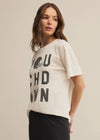 Woman wearing a white t-shirt with text on a beige background