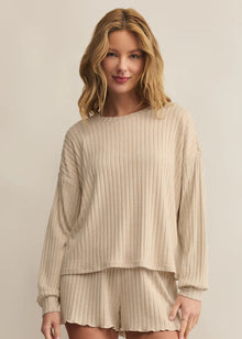  Woman wearing a beige ribbed lounge set against a plain background