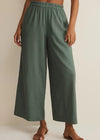 Person wearing green wide-leg pants on a plain background
