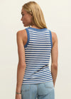 Woman wearing a blue and white striped tank top and light blue jeans on a plain background