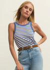 Woman wearing a blue and white striped tank top and light blue jeans against a plain background