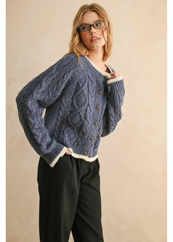 Woman wearing a blue knitted cardigan with a beige background