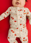 Baby wearing a floral onesie against a red background
