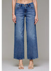 Blue jeans worn by a person on a gray background