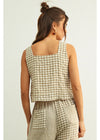 Woman wearing a checkered outfit on a plain background