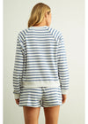 Person wearing a blue and white striped pajama set on a plain background