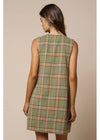A woman shown from the back wearing a sleeveless olive green plaid dress with red and white lines, set against a solid beige studio background.