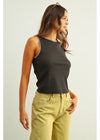 Woman wearing a dark gray tank top with a light-colored background