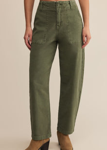  Person wearing olive green pants on a beige background