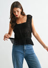 Woman wearing a black top and blue jeans on a white background