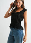 Woman wearing a black peplum top and blue jeans on a white background
