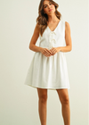 Woman wearing a white dress against a plain background